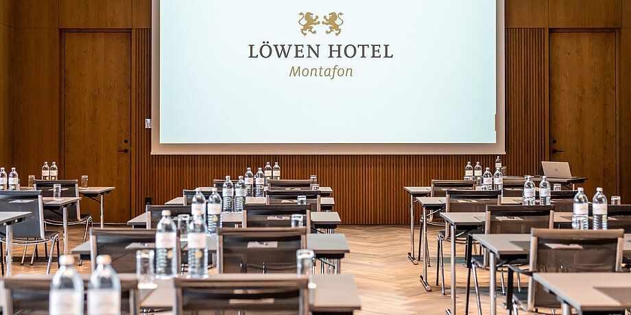 Large conference hall with rows of chairs and tables and technical equipment in the Löwen seminar hotel in Vorarberg