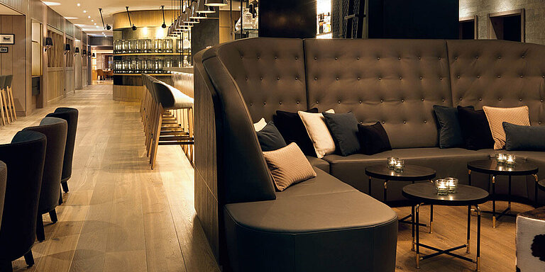 Eine Lounge steht an mehreren Rundtischen im Löwen Hotel Montafon