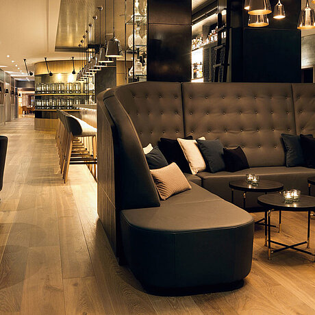 Eine Lounge steht an mehreren Rundtischen im Löwen Hotel Montafon