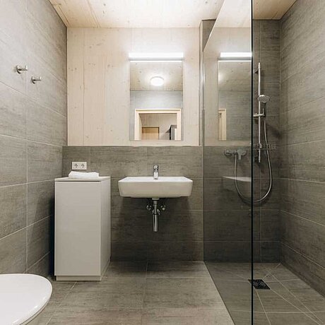 Blick in ein Badezimmer im Teamhaus des Löwen Hotel Montafon