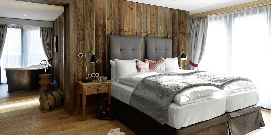 Traditionell modern eingerichtetes Hotelzimmer mit Doppelbett und Badewanne 