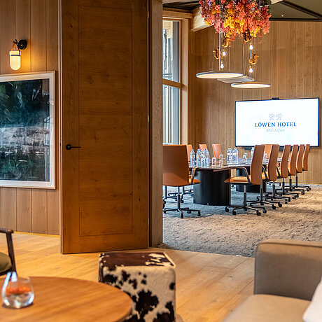Blick vom Break-Out-Raum auf einen modern ausgestatteten Seminarraum im Löwen Seminarhotel in Vorarlberg