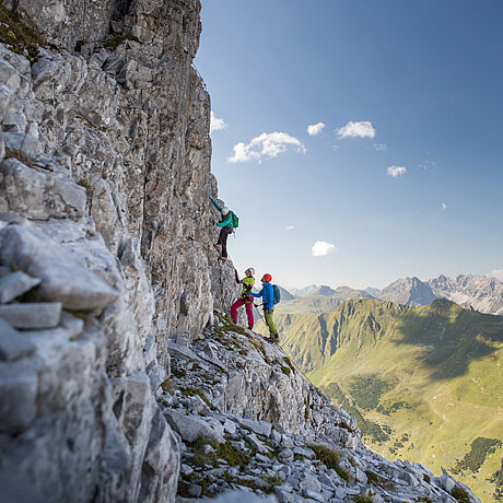 Drei Kletterer wagen den Aufstieg am Klettersteig Gauablickhöhle nahe des Löwen Hotel Montafon
