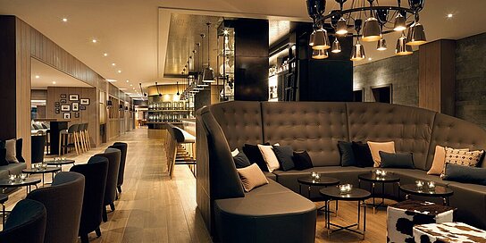 Elegant lobby with dark furnishings and hotel bar at the Löwen Hotel Montafon