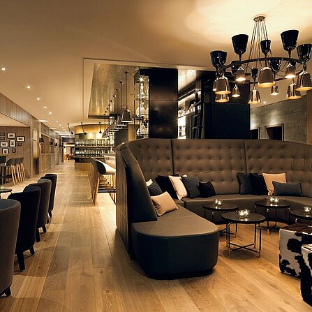 Elegant lobby with dark furnishings and hotel bar at the Löwen Hotel Montafon