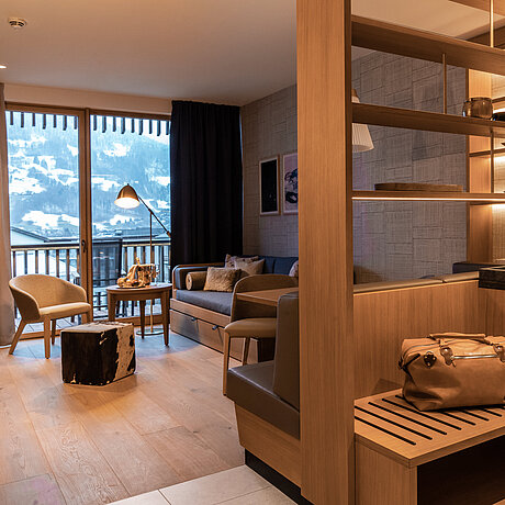 Helles Mobiliar im Wohnbereich des Deluxe Zimmer mit großzüigem Balkon und Panoramablick